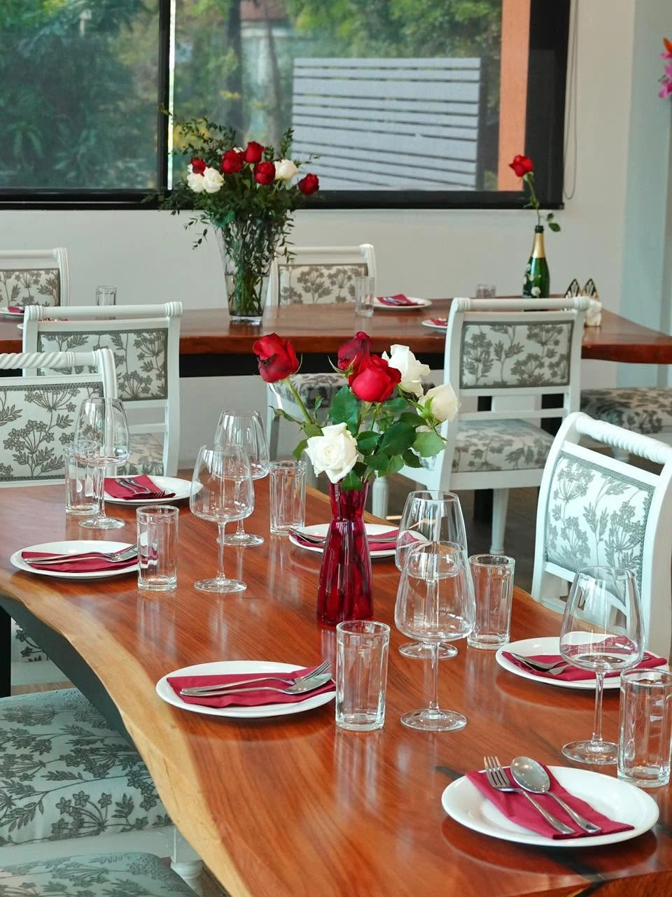 A long wooden table set with roses for private dining at UPPER·T